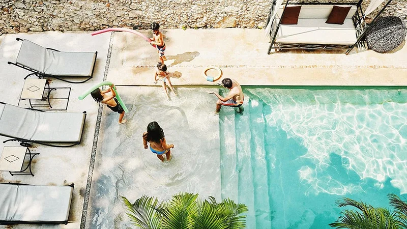 Image description: Family playing together in resort swimming pool