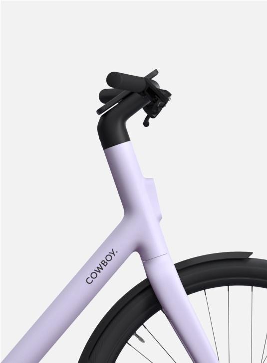 A photographic render. From the side, detail of the front wheel and handle bars of a Cowboy Cruiser ST in Lavender. colourway