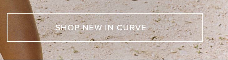 Close-up of sun-kissed tan skin against sandy ground, featuring a white overlay with 'SHOP NEW IN CURVE' to promote the latest plus-size collection.