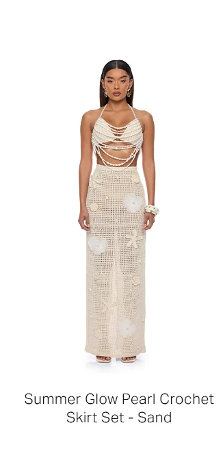 Model in radiant sand pearl crochet skirt set. Halter top with draped pearls, full-length skirt with delicate sea motifs, perfect for summer style.
