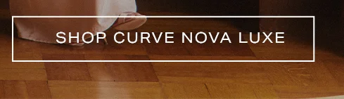 White 'SHOP CURVE NOVA LUXE' text in a banner over a light-toned foot on a wooden floor. Discover the new Curve Nova Luxe collection.