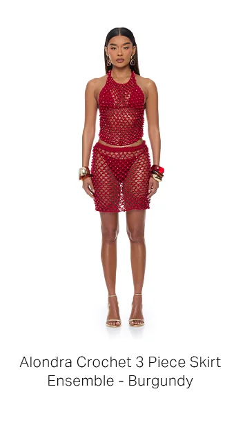 Model wears a full burgundy Alondra crochet 3-piece ensemble: halter top, mini skirt over bikini bottom. Styled with gold heels.