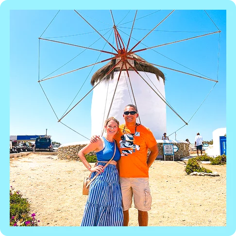 Image description: A man and a woman posing side by side in front of a white windmill