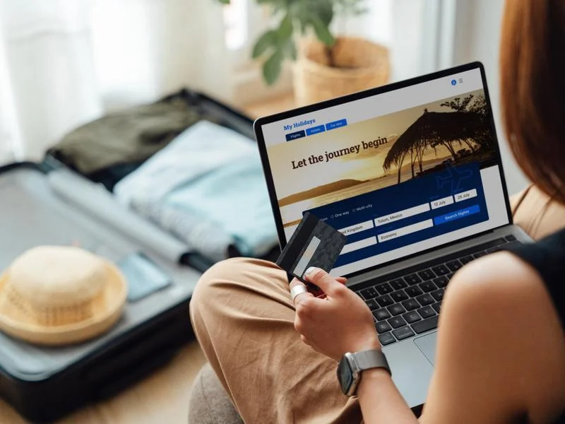 Woman paying with a credit card while booking a trip online