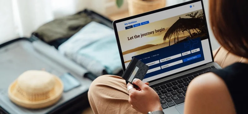 Woman paying with a credit card while booking a trip online