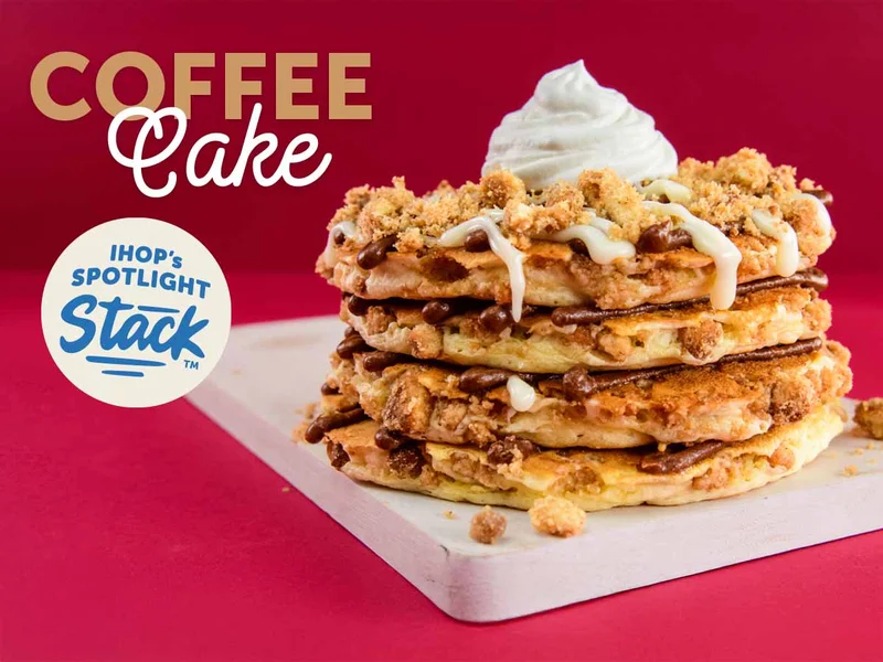 A full stack of Coffee Cake Pancakes with whipped topping.