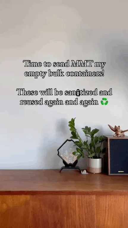 A hand places three empty bottles on a table