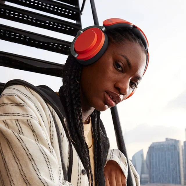 A model wearing Dyson OnTrac headphones in Ceramic Cinnabar color combo
