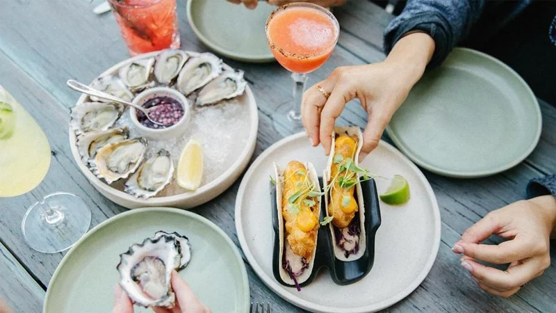 Image description: Overhead shot of diners eating oysters and fish tacos at North Bondi Fish, Sydney.
