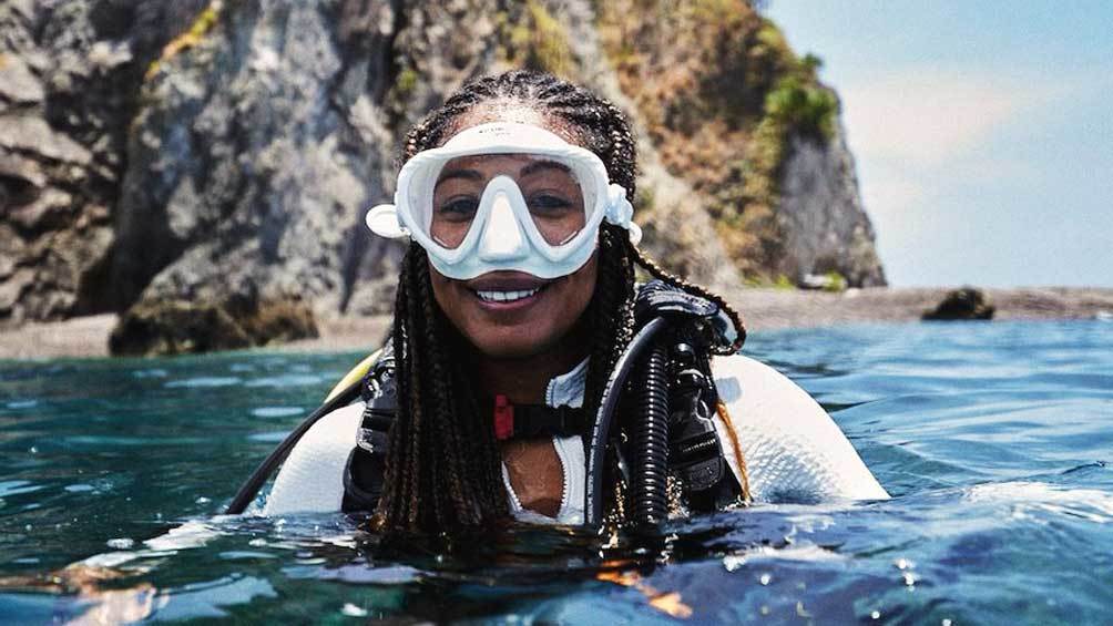 Image description: Portrait of Black woman (Adrienne Jordan) on the water while scuba diving.