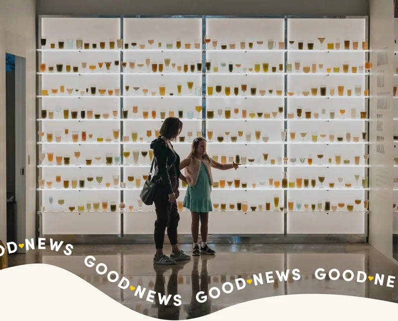 A woman and girl stand in front of the water wall at The Experience Lab.
