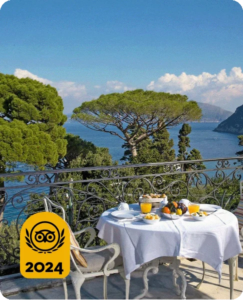 Image Description: A table with a breakfast spread on a balcony overlooking the water. A gold 2024 Travelers’ Choice Awards Best of the Best badge is on the bottom left corner of the image.