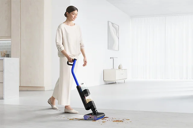 Woman cleaning mess from a hard floor with the Dyson WashG1 wet cleaner