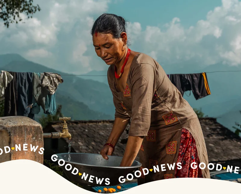 A woman hand washes clothing and hangs them on a clothing line.