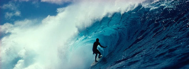 A surfer in the tube of a wave.