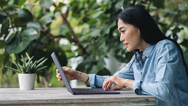 Woman working outside using a Dell 14 Plus Non-Touch Laptop
