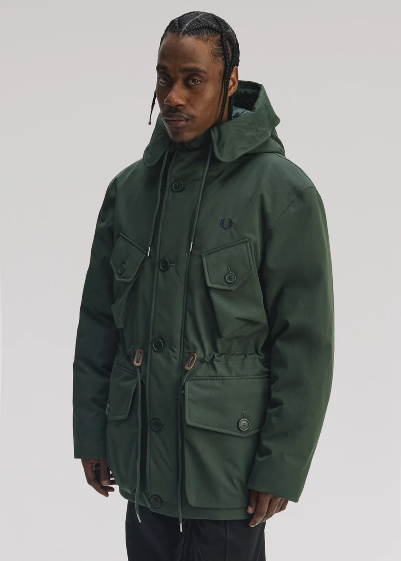 Male model wearing a Fred Perry Patch Pocket Puffer Jacket in Court Green