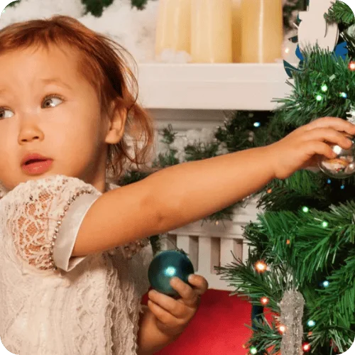 a toddler girl who is about to mess up the christmas tree a toddler girl who is about to mess up the christmas tree