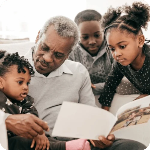 a grandfather looking through a family photo book with his grandkids a grandfather looking through a family photo book with his grandkids