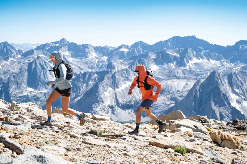 Two people trail run above timberline.