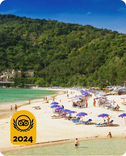 Image Description: A sandy beach with purple umbrellas and blue lounge chairs surrounded by green mountains. A gold Travelers’ Choice Awards Best of the Best 2024 badge is on the bottom left corner.
