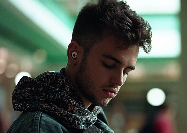 A man in the city looks down thoughtfully.