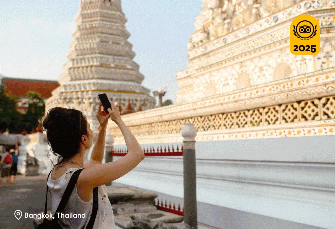 Image Description: A rotating GIF featuring popular destinations around the world, including a traveler taking a photo of the famous Wat Pho temple in Bangkok, a tour guide telling stories to a couple outside the Colosseum in Rome, and a solo traveler enjoying a picturesque view of Azenhas do Mar, a cliffside village in Lisbon. A gold 2025 Travelers’ Choice Awards Best of the Best badge is on the top right of each image.