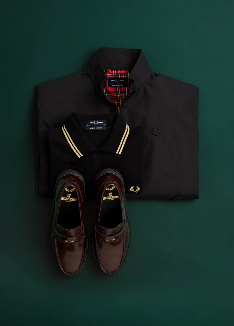 Male model with wolf cut wears a long sleeved Fred Perry shirt