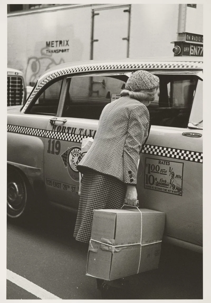 Woman standing outside of a taxi with a shopping bag
