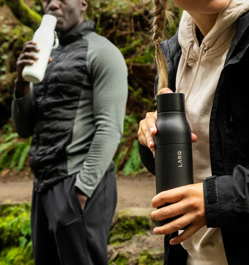 Man and woman holding LARQ Bottle PureVis and LARQ Bottle Filtered