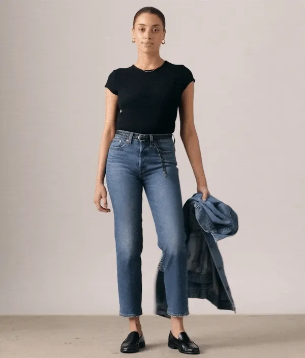 Gif of a woman standing wearing a black tee and blue jeans.