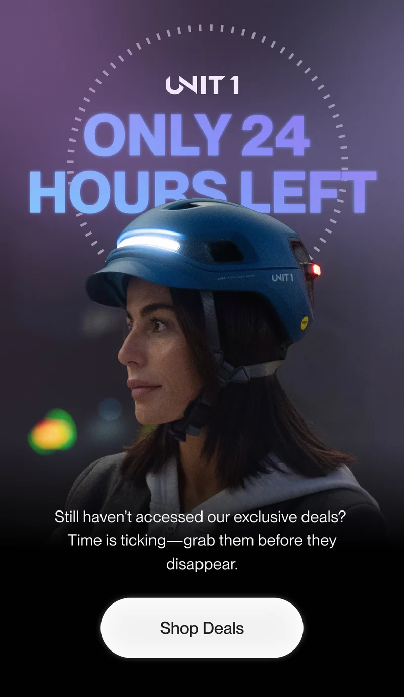 Female cyclist wearing a UNIT 1 smart helmet with integrated front and rear lighting.