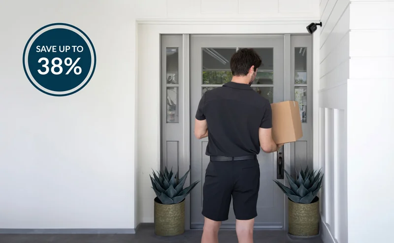 Save up to 38%. Delivery driver standing at the front door of a house with a package near a Pro 5S 2K Camera mounted on the wall.