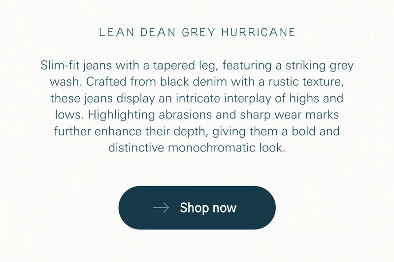 Slim-fit jeans with a tapered leg, featuring a striking grey wash. Crafted from black denim with a rustic texture, these jeans display an intricate interplay of highs and lows. Highlighting abrasions and sharp wear marks further enhance their depth, giving them a bold and distinctive monochromatic look.