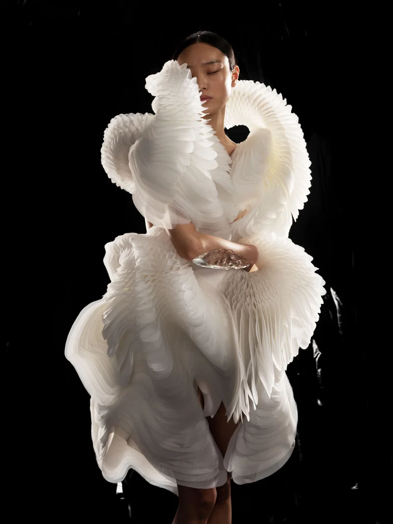 A woman wearing an intricate white dress