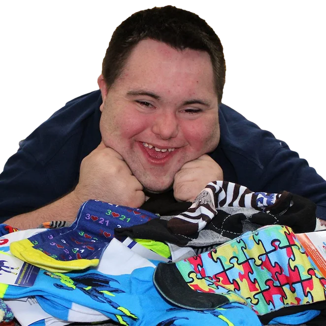 John smiling and looking at a pile of socks on a table