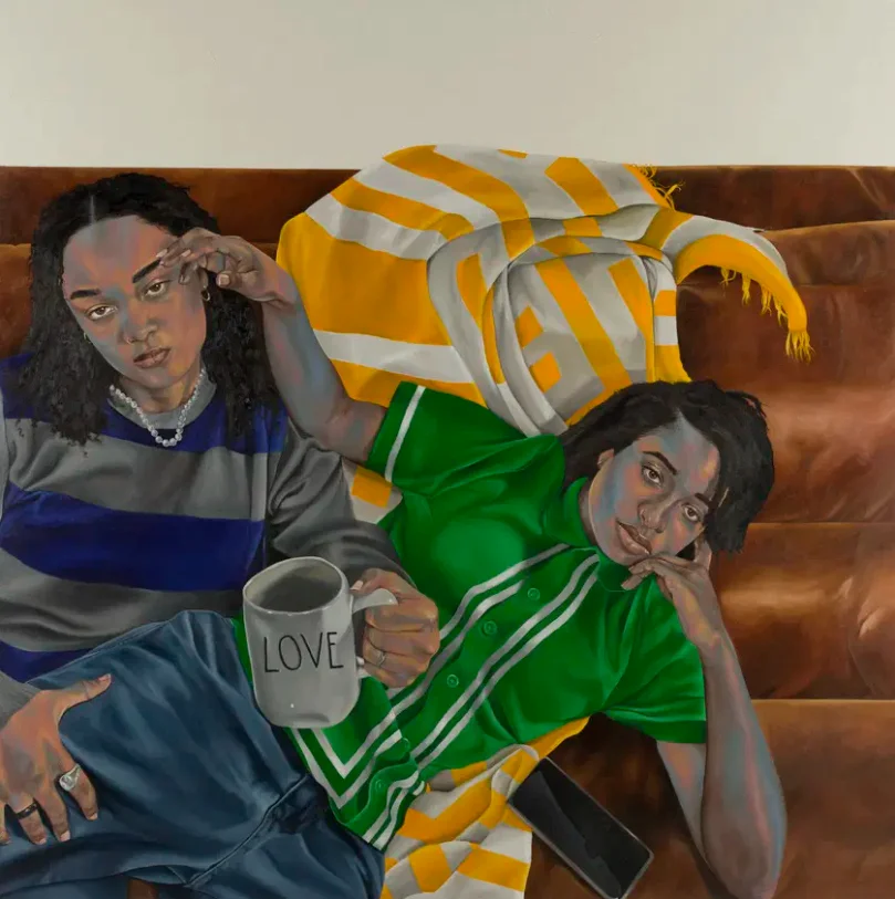 Painting of two people cuddling on a couch, one holding a mug reading "Love"