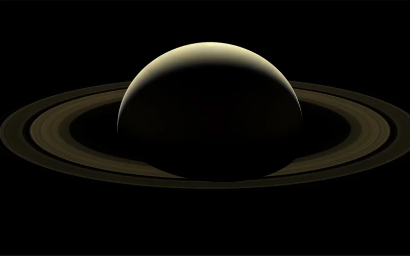 A natural-color view of Saturn as seen from NASA's Cassini spacecraft after more than 13 years of surveying the gas giant. Six of Saturn's moons—Enceladus, Epimetheus, Janus, Mimas, Pandora and Prometheus—make a faint appearance in this image. (Numerous stars are also visible in the background.)