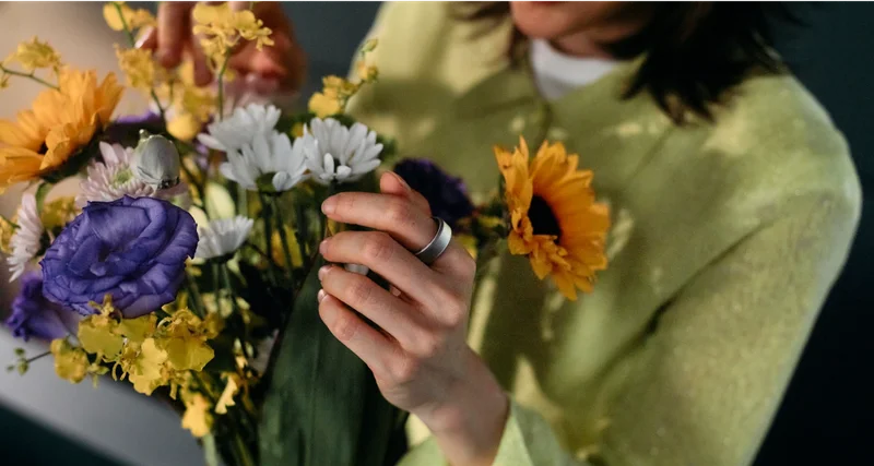 Person holding flowers wearing Oura Ring