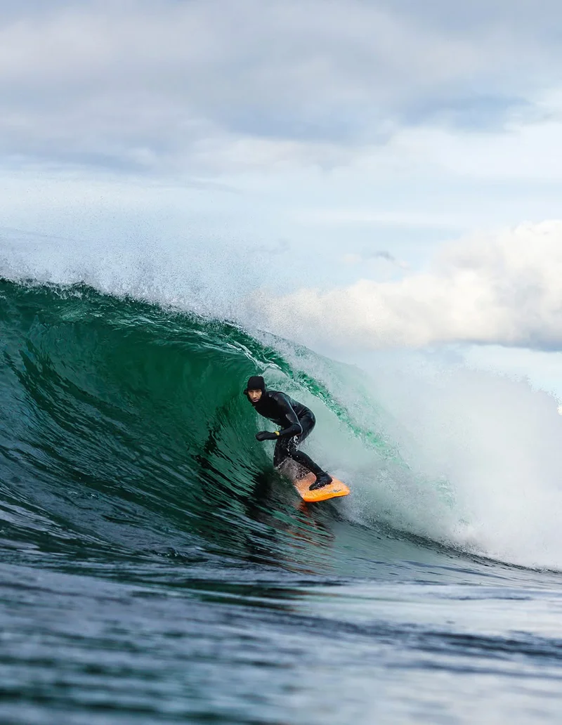 A surfer tucks into a barreling wave.
