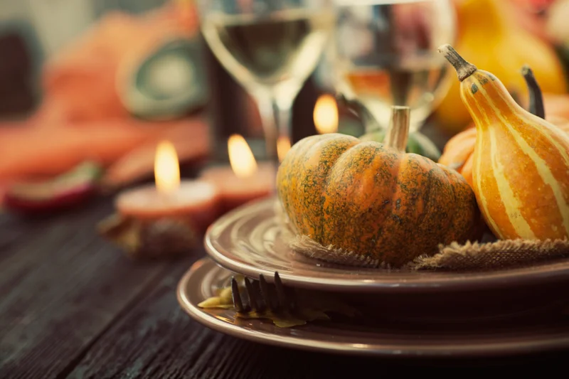 Fall tablescape with orange gourds and lighted candles