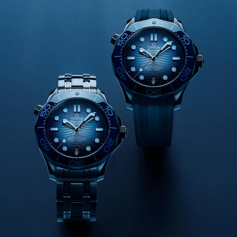 Two OMEGA Seamaster watches with Summer blue dials on a dark background.