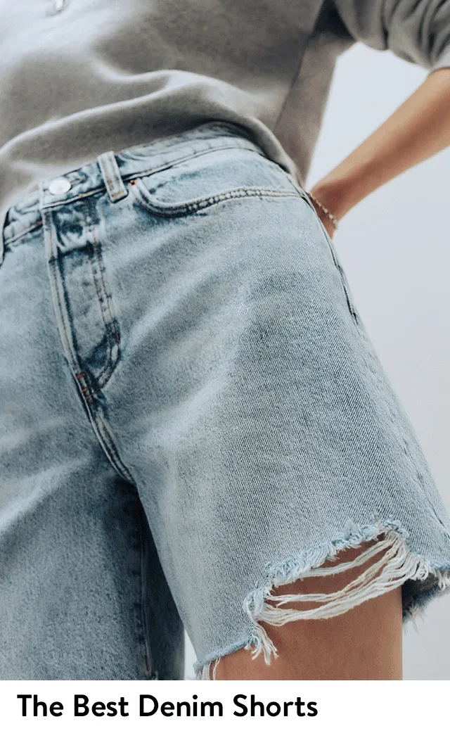 A woman wearing cutoff denim shorts with a sweater and heeled sandals.