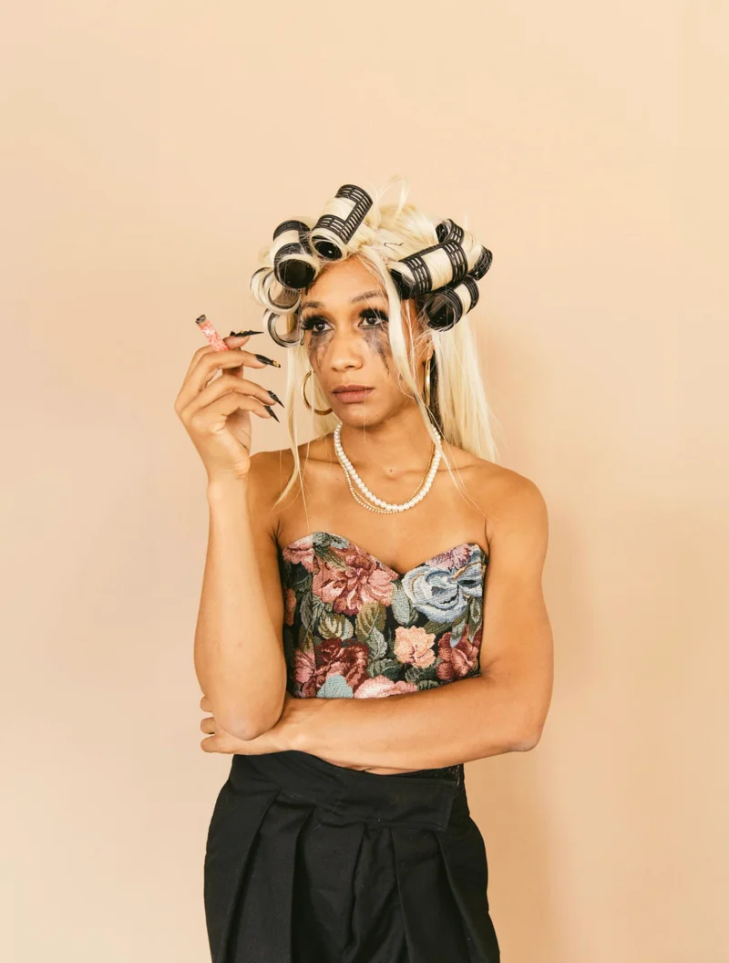 A woman with hair curlers and mascara running down her face