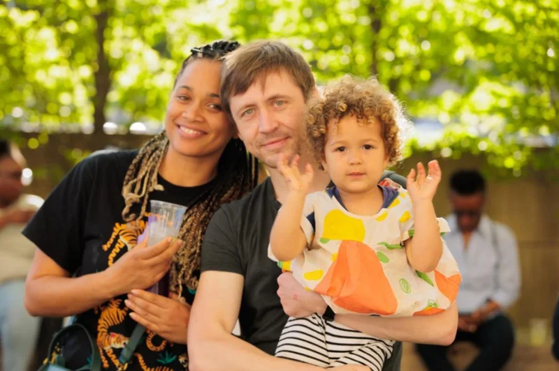 Two adults holding a child and smiling