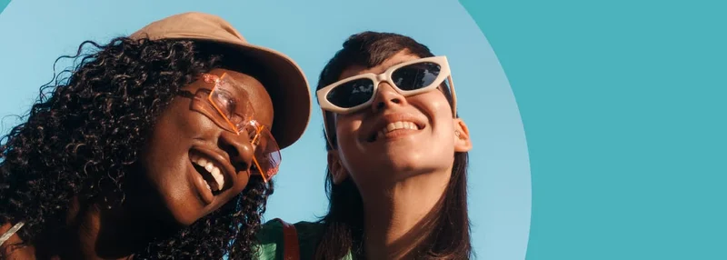 Two women smile happily in the sunshine.