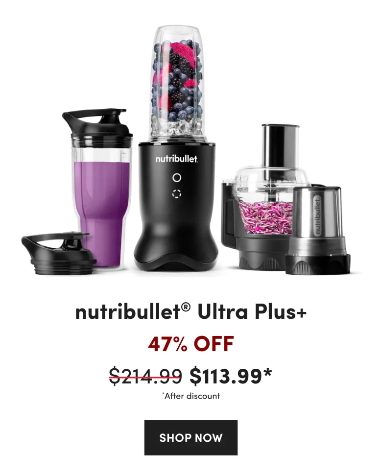 A nutribullet blender filled with berries and ice next to a purple smoothie and food processor.