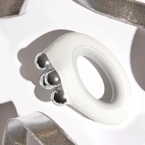 NuBODY Device against white background with silver ribbons.