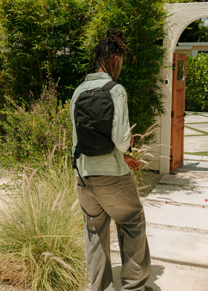 an image of a man with a backpack standing on a sidewalk
