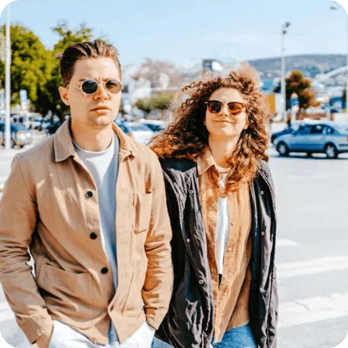 a couple walking and the man looks unhappy while the woman smiles a couple walking and the man looks unhappy while the woman smiles